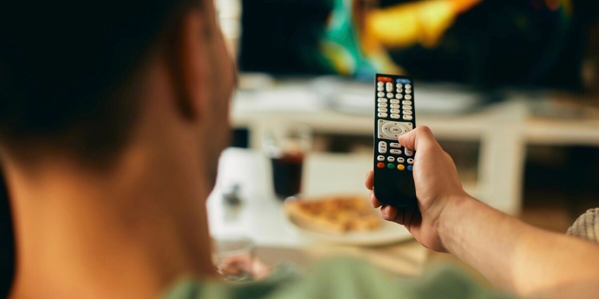 Man holding television remote