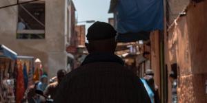 Man walking on narrow and crowded street