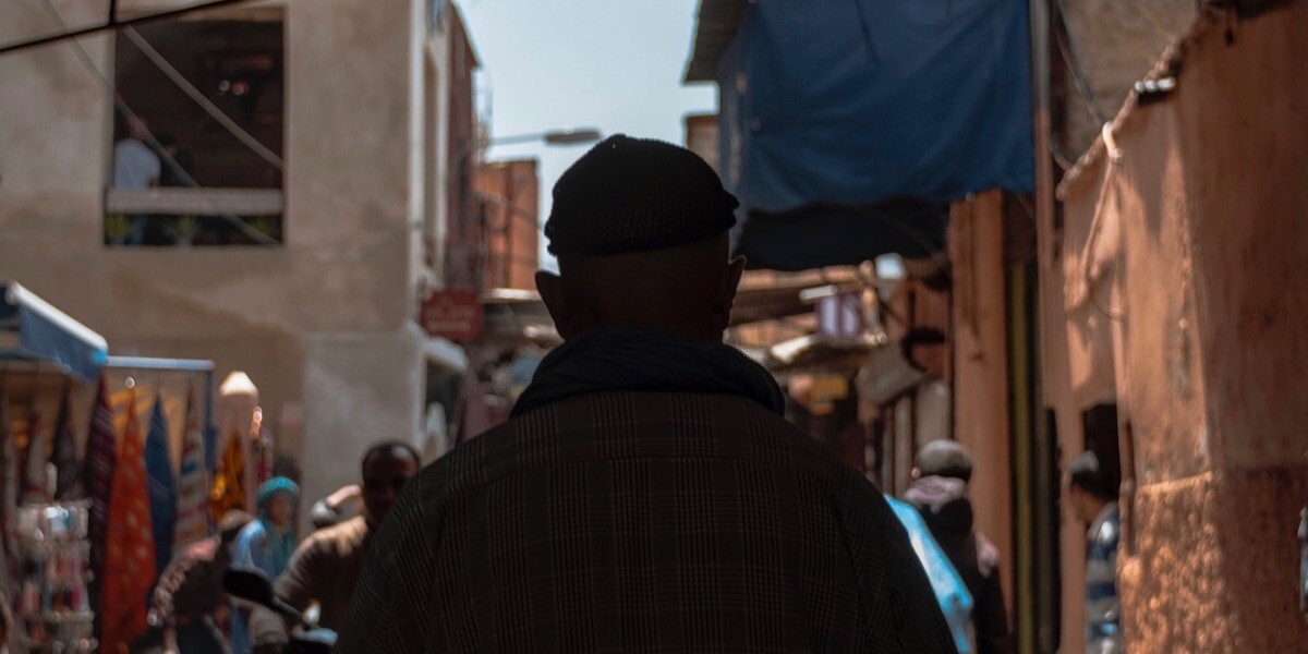 Man walking on narrow and crowded street